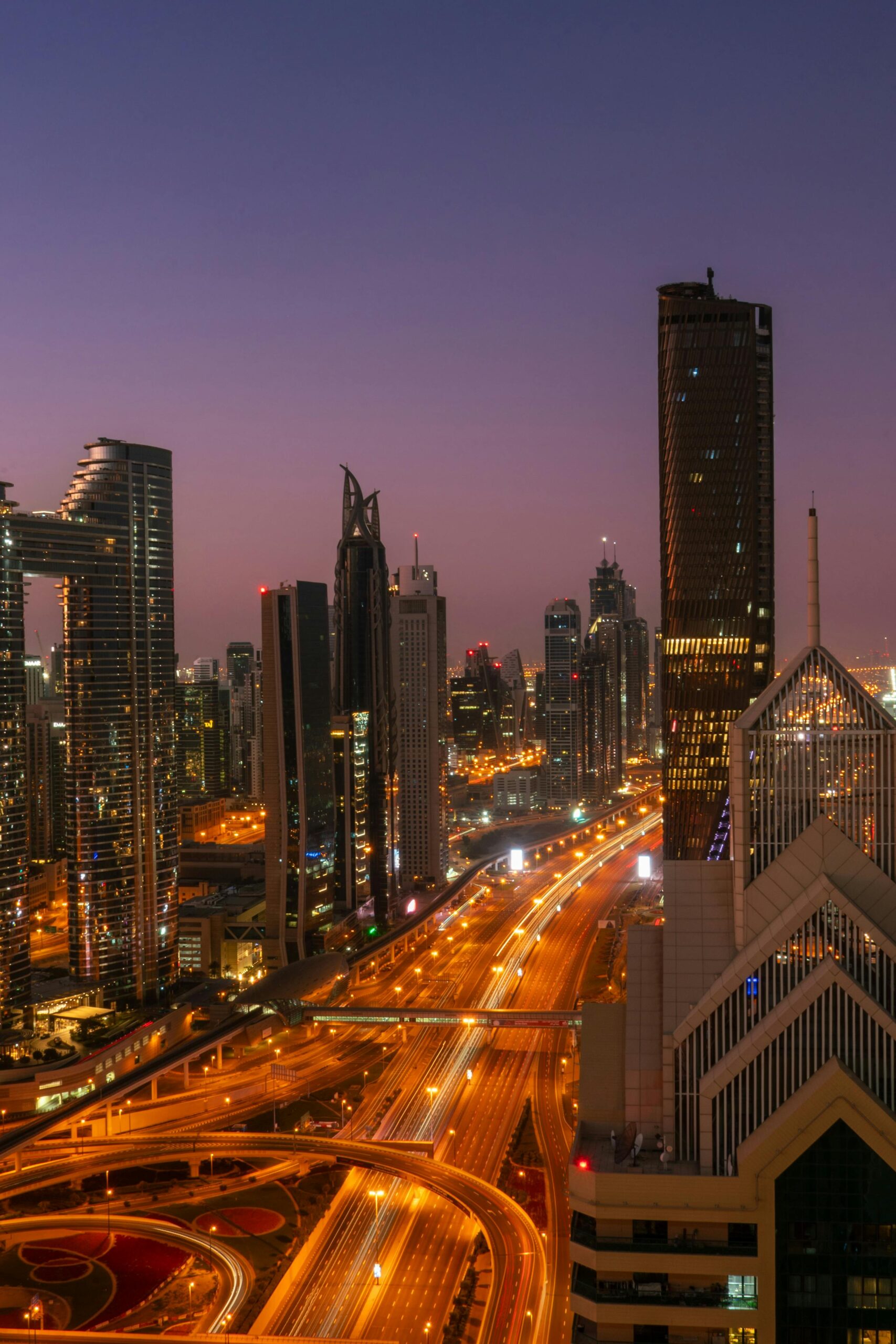 A stunning twilight view of Dubai's modern skyline with illuminated roads and skyscrapers.
